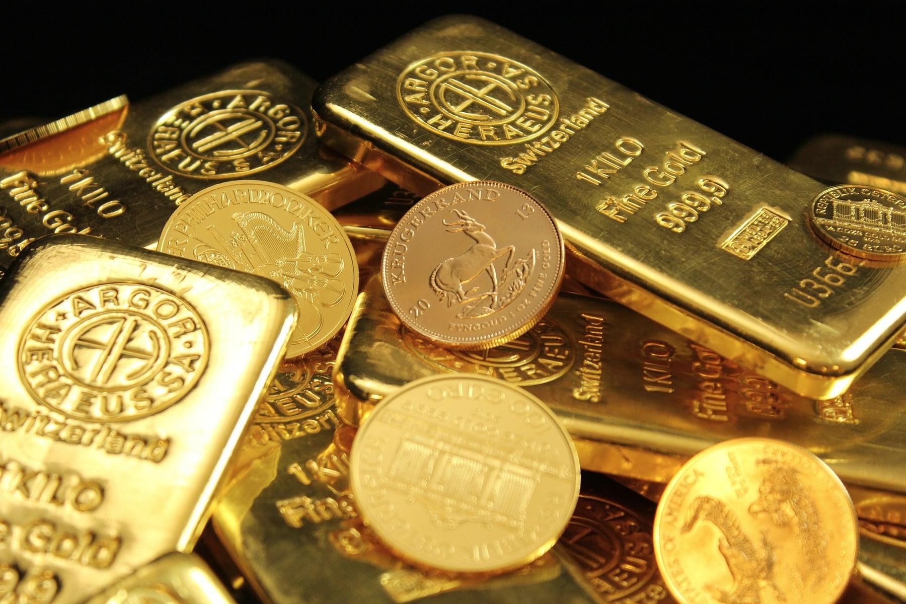 Close-up of gold bars stacked next to gold bullion coins