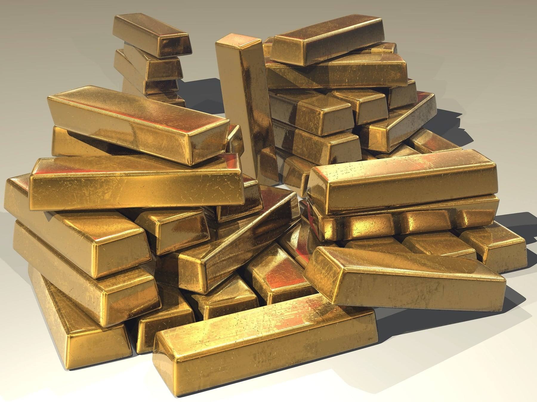 A pile of stacked gold bars lit by warm studio light